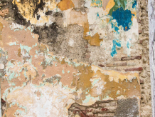 wall with many coats of paint and plaster